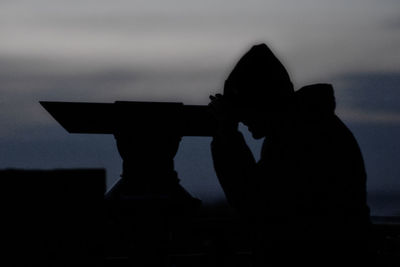 Silhouette man photographing against sky during sunset