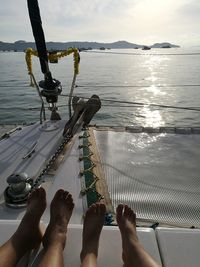 Low section of woman on sea against sky