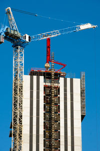 Low angle view of crane against sky