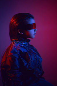 Portrait cyberpunk boy child in vr glasses in blue and red tones. game, virtual reality