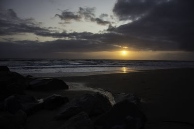 Scenic view of beach against sky during sunset