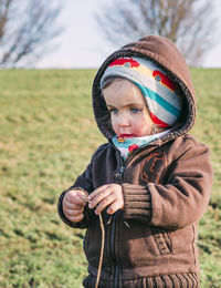 Cute boy looking away on field