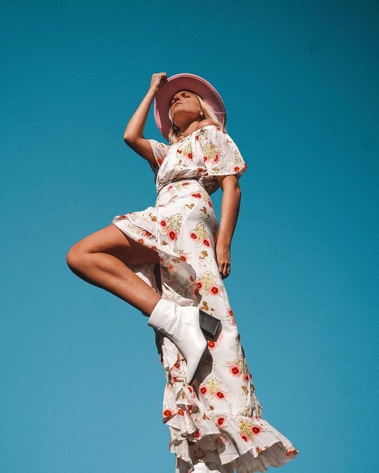 LOW ANGLE VIEW OF WOMAN STANDING AGAINST CLEAR SKY