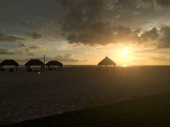 Scenic view of beach against sky at sunset