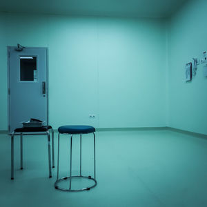 Empty chairs and table against wall in building