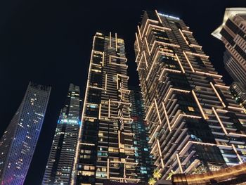 Low angle view of illuminated buildings against sky at night