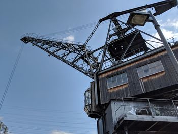 Low angle view of cranes against sky