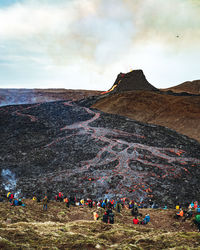 Group of people on field against mountain range