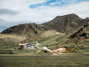 Scenic view of houses and mountains against sky