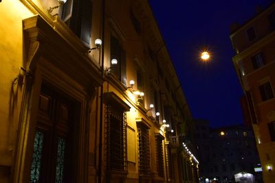 Low angle view of illuminated buildings against sky at night