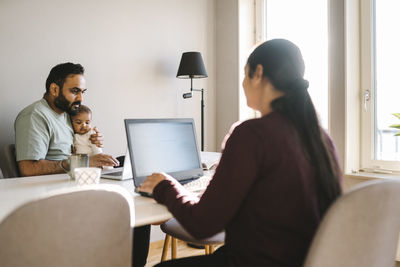 Parents with baby using their laptops