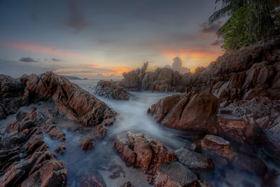 Scenic view of waterfall against sky during sunset