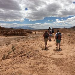 People walking on desert against sky
