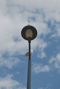 Low angle view of street light against cloudy sky