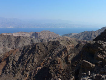 Rocky mountains and sea against clear sky