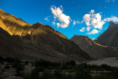 Panoramic view of landscape and mountains against blue sky