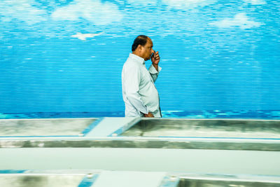 Full length of man standing by swimming pool