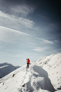 Rear view of man walking on snow covered mountain