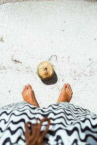 Low section of person standing on sand at beach