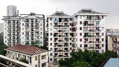Residential buildings in city against sky
