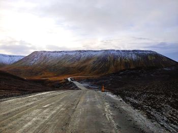 Road by mountain against sky