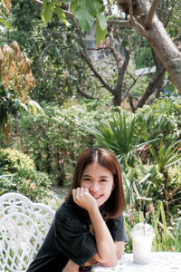 Portrait of a smiling young woman sitting outdoors