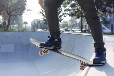 Low section of man skateboarding in park