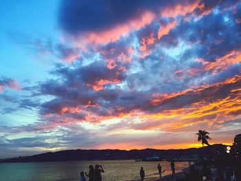 Scenic view of sea against cloudy sky at sunset