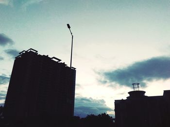 Low angle view of silhouette buildings against sky