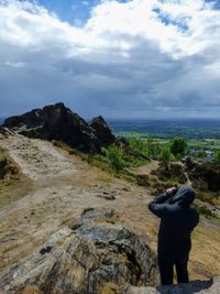 High angle view of man photographing while standing against landscape