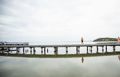 Man standing on bridge against sky