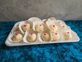 Chocolate balls covered in coconut on table