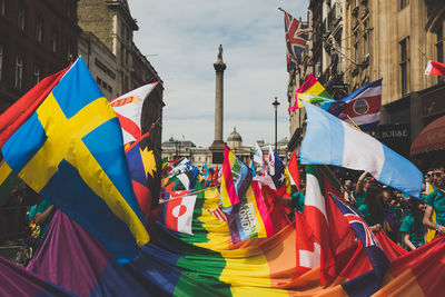 Crowd carrying colorful flags in city during parade