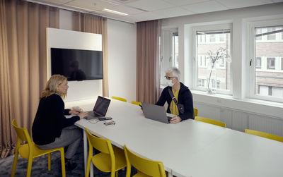 Man and woman working together in board room