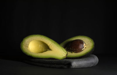 Close-up of fruits on table against black background