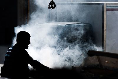 Side view of silhouette man preparing food