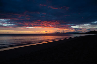 Scenic view of sea against dramatic sky during sunset