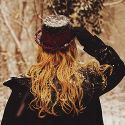 Rear view of woman wearing hat standing outdoors