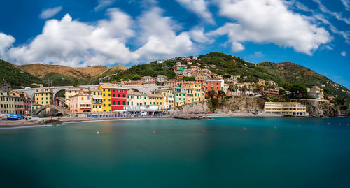 Scenic view of town by sea against sky