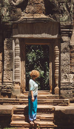 Full length rear view of man outside temple against building