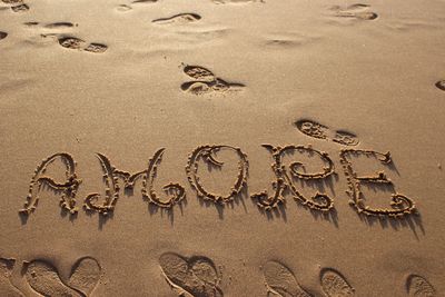 High angle view of text on sand at beach