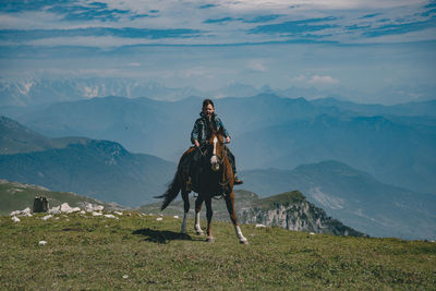 Boy sitting on horse at mountain