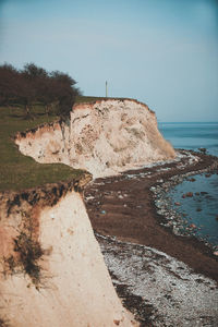 Rock formation on beach against sky