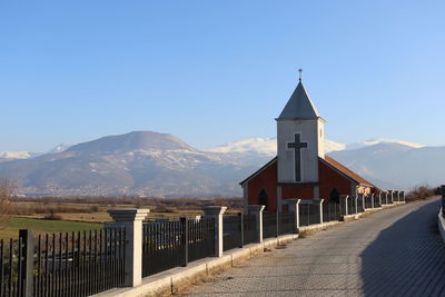 Panoramic view of building and mountains against blue sky