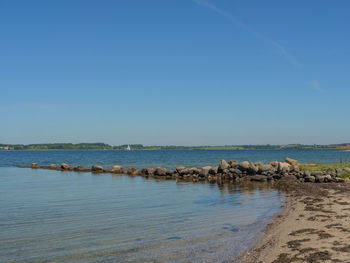 Scenic view of sea against clear blue sky