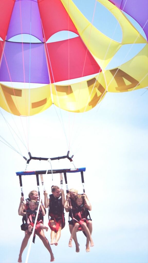 low angle view, lifestyles, leisure activity, sky, fun, men, enjoyment, person, multi colored, hanging, childhood, large group of people, umbrella, balloon, clear sky, day, arts culture and entertainment, amusement park, casual clothing