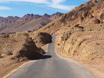 Asphalt road leading through steaming hot landscape of death valley national park