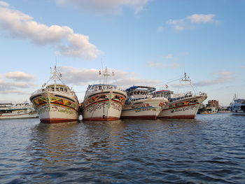 Boats moored in water against sky