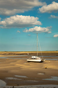 Sailboat on beach against sky