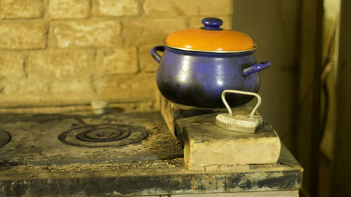 Close-up of rusty old stove top with pot and retro iron